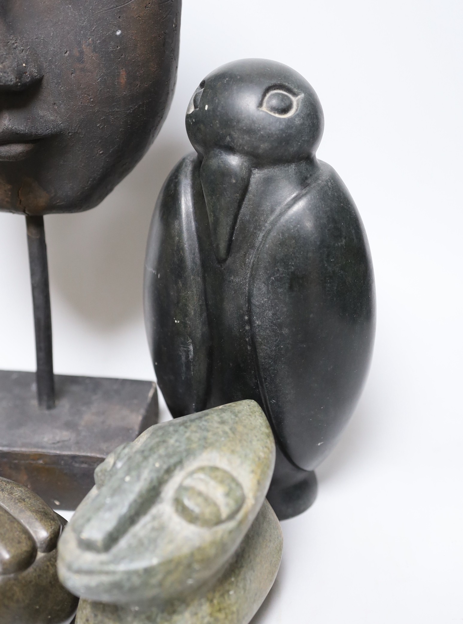 Three Inuit sculptures, a mask on stand and buddhist head, mask 39cms high